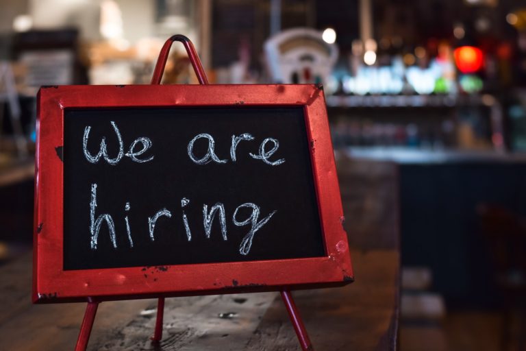 We are hiring sign in a restaurant, bar or diner, businesses experiencing shortage of workers