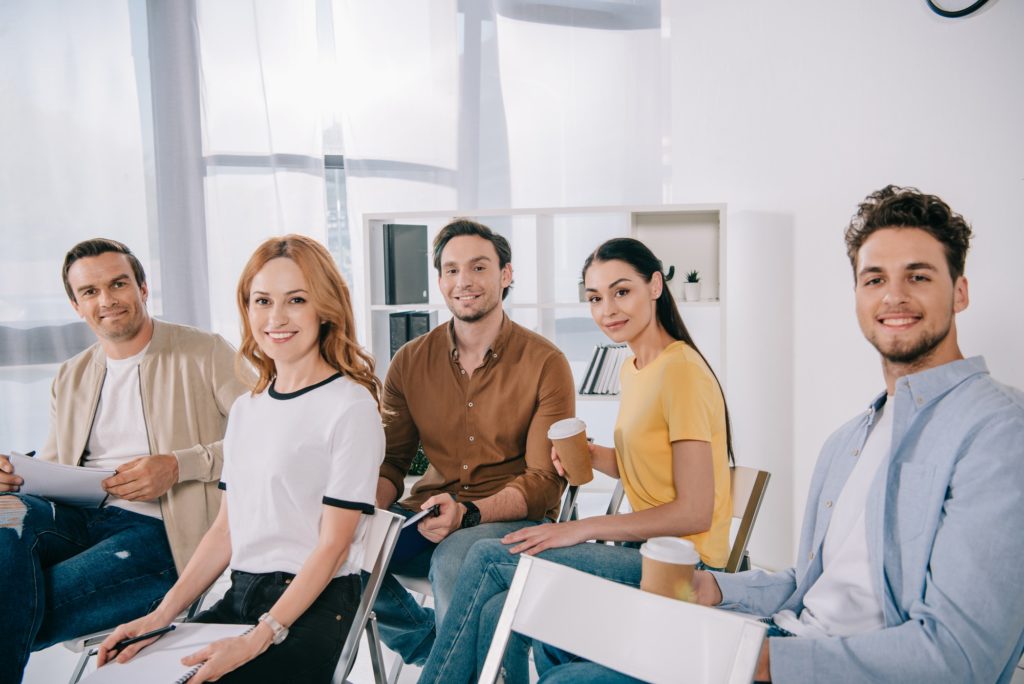 smiling business people in casual clothing having business training in office